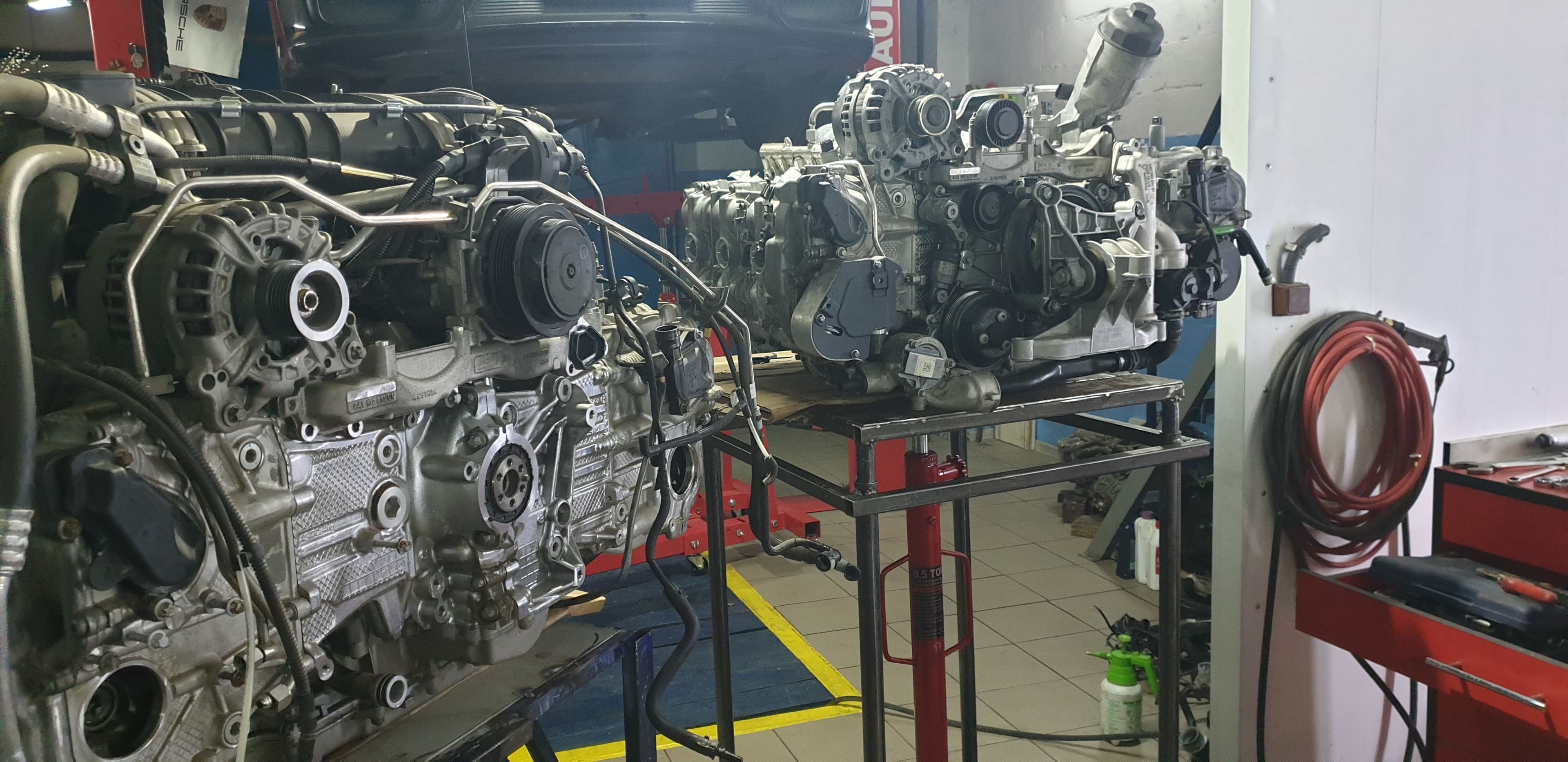 Two Porsche engines on workshop stands during the 981 Cayman's 3.8-liter conversion.